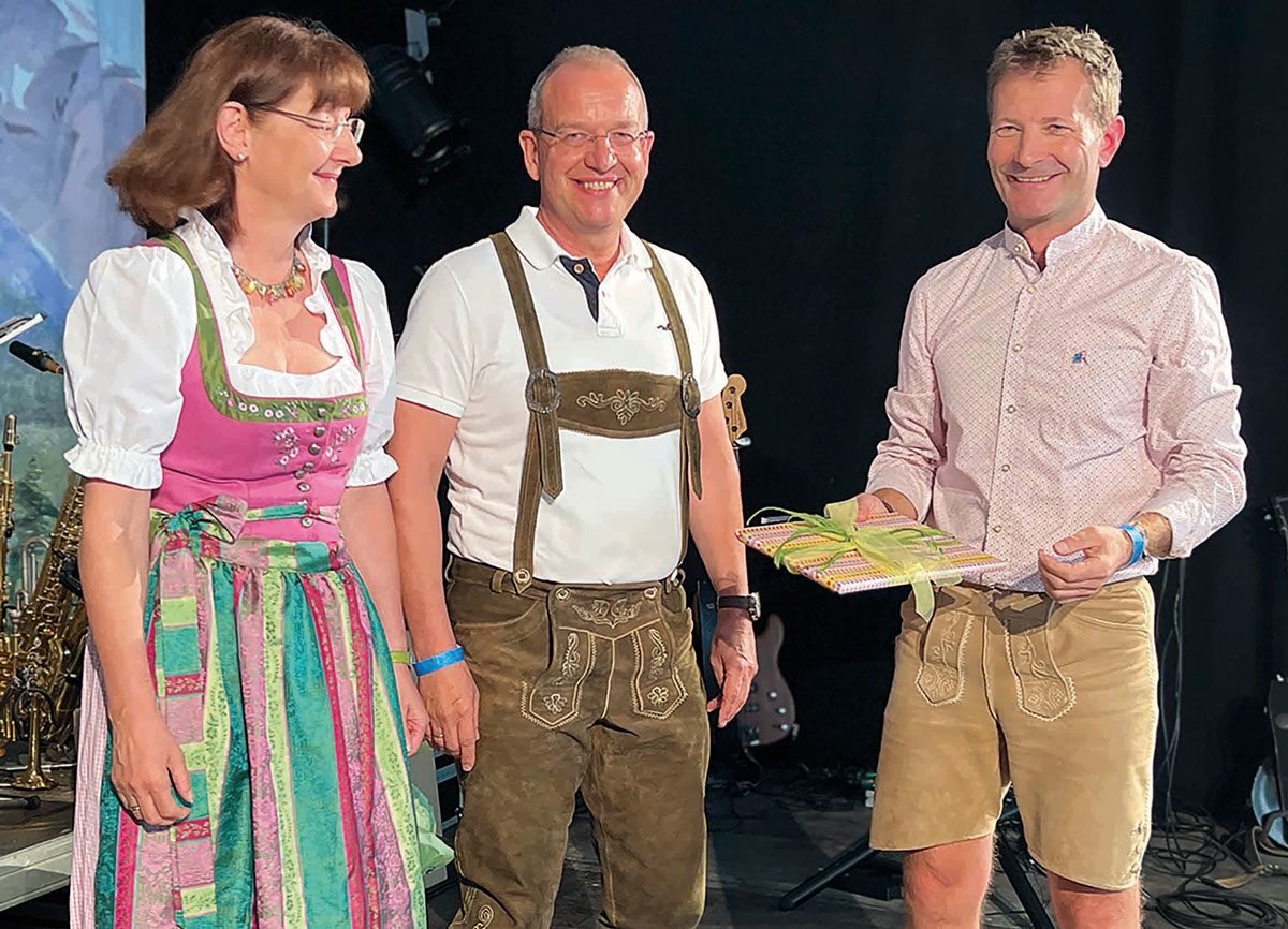 Verabschiedung von Geschäftsführer Oliver Stockinger mit Ehefrau Herta und Geschäftsführer Rudolf Schnauhuber auf der Bühne beim Mitarbeitendenfeier am 30. Juni 2023.